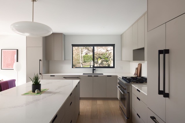 Kitchen after — warm grey cabinetry and quartz island