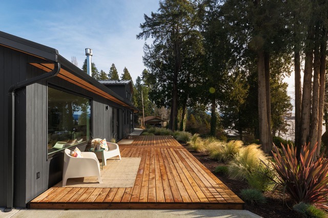 Cedar deck with white chairs overlooking the garden and trees